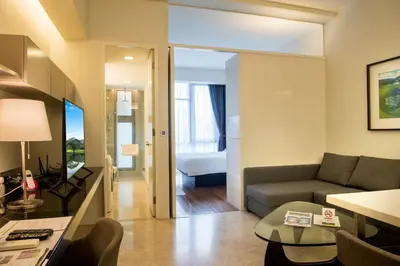 a living room with a couch and a room with a bed at The Signature Hotel & Serviced Suites Hartamas Kuala Lumpur in Kuala Lumpur