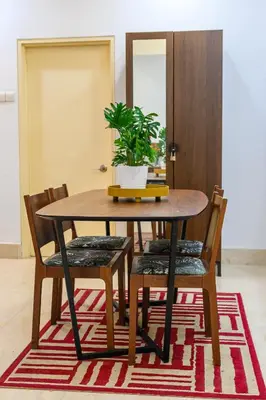 a dining room table with chairs and a potted plant at Fahrenheit 88 Kuala Lumpur in Kuala Lumpur