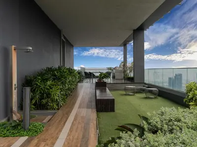an outdoor deck with benches and grass on a building at Star Premier KLCC Suite 3-4pax by LavishHome in Kuala Lumpur