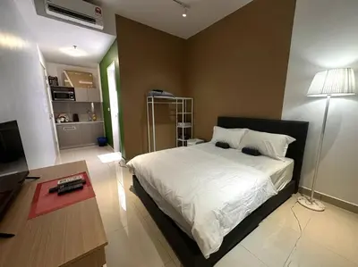 a bedroom with a white bed and a table and a room at KLCC view cozy studio apartment Trion C243A KL in Kuala Lumpur