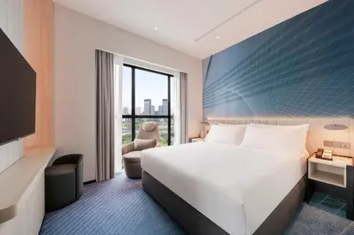 a hotel room with a bed and a large window at Holiday Inn Kuala Lumpur Bangsar by IHG in Kuala Lumpur