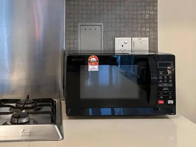 a microwave sitting on a counter next to a stove at Bintang Fairlane Residence, Cozy Fam Suite with Bathtub - 2B2R in Kuala Lumpur