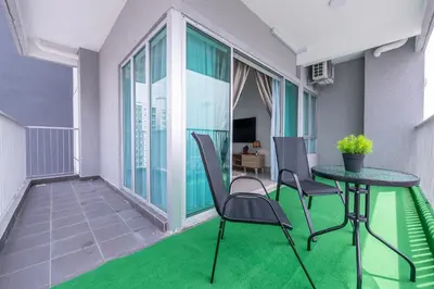 a balcony with a table and chairs and green carpet at 5min to KL TRX Bukit Bintang for 6paxs in Kuala Lumpur