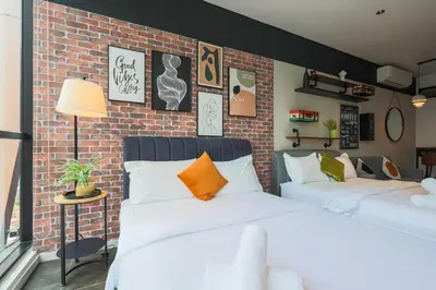 two beds in a room with a brick wall at Scarletz Suites KLCC by GB in Kuala Lumpur