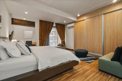 a bedroom with a large white bed and a couch at Fahrenheit 88 Pavillion Bukit Bintang 3 bedroom in Kuala Lumpur