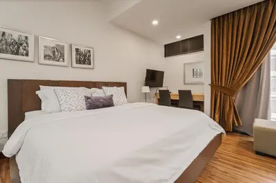 a bedroom with a large white bed and a desk at Fahrenheit 88 Pavillion Bukit Bintang 3 bedroom in Kuala Lumpur