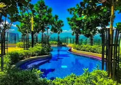 a pool in the middle of a park with trees at robertson by katie suites in Kuala Lumpur