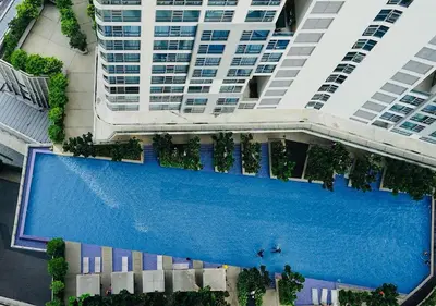 an overhead view of a swimming pool in front of a tall building at robertson by katie suites in Kuala Lumpur