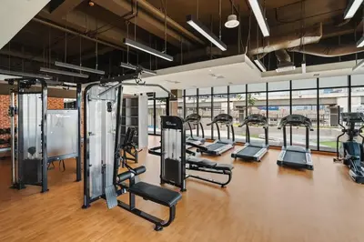 a gym with a row of treadmills and ellipticals at Lemon Loft 2BR opposite MyTown near TRX by RumaBnB in Kuala Lumpur