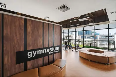 a lobby with a gymnasium with a couch and a table at Lemon Loft 2BR opposite MyTown near TRX by RumaBnB in Kuala Lumpur
