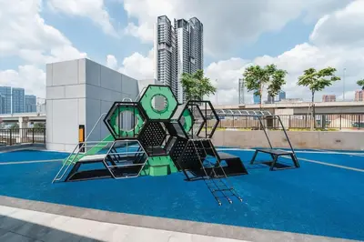an empty playground with two chairs and a building at Lemon Loft 2BR opposite MyTown near TRX by RumaBnB in Kuala Lumpur