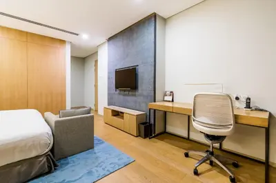 a bedroom with a desk and a bed and a chair at 188 Premium Suites by Plush in Kuala Lumpur