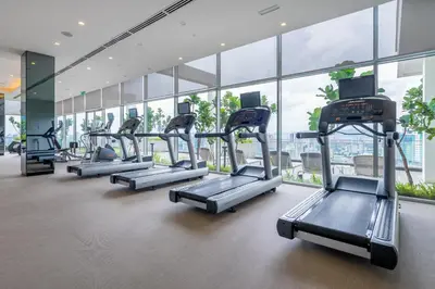 a row of treadmills in a gym with windows at 188 Premium Suites by Plush in Kuala Lumpur