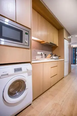 a kitchen with a washing machine and a microwave at 188 Premium Suites by Plush in Kuala Lumpur