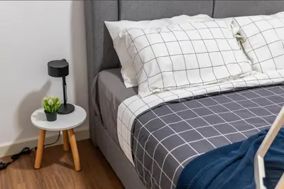 a bedroom with a bed and a table with a lamp at M-Vertica Sunway Velocity Cheras by Luvit Stay in Kuala Lumpur