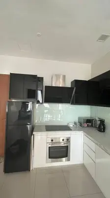 a kitchen with a black refrigerator and white cabinets at City Centre KLCC in Kuala Lumpur