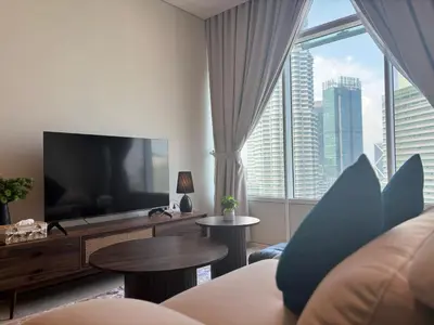a living room with a large television and a large window at SkySuites Luxury Suite By CalmSojourn in Kuala Lumpur