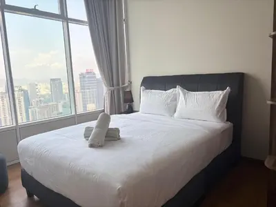 a bed in a room with a large window at SkySuites Luxury Suite By CalmSojourn in Kuala Lumpur