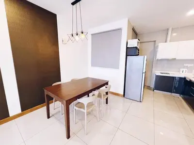 a kitchen with a table and chairs and a refrigerator at PROMO 2 ROOM Nice Design KL Gateway Residence 27 in Kuala Lumpur