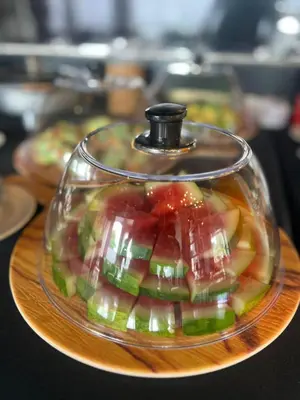 a glass dish filled with fruit on a cutting board at Kingston Hotel 4 - Hulo Bukit Bintang in Kuala Lumpur