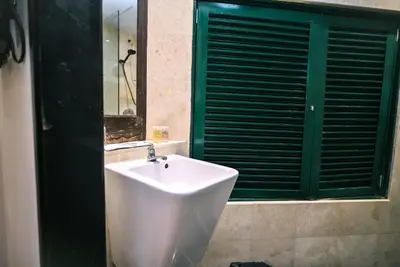 a white sink in a bathroom with a green window at Kingston Hotel 4 - Hulo Bukit Bintang in Kuala Lumpur