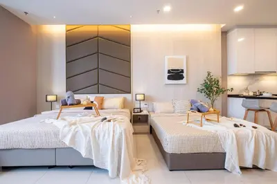 a bedroom with two beds and a kitchen at Societe Studio Sri Hartamas By Feel Home in Kuala Lumpur