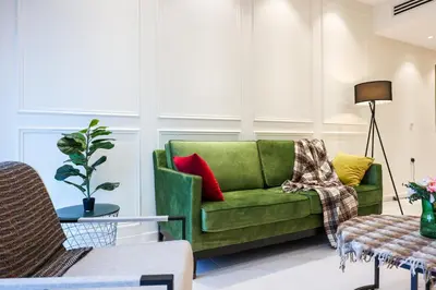 a living room with a green couch with colorful pillows at Eaton Residence KLCC by GB in Kuala Lumpur
