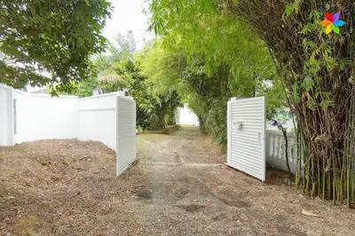 a white fence with two doors in a yard at 30P White House Retreat - Pool & Event Hall in Kuala Lumpur