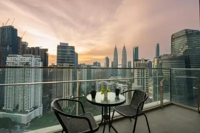 a table and chairs on a balcony with a city skyline at Moonway Luxury Suites At TM KLCC City Center in Kuala Lumpur