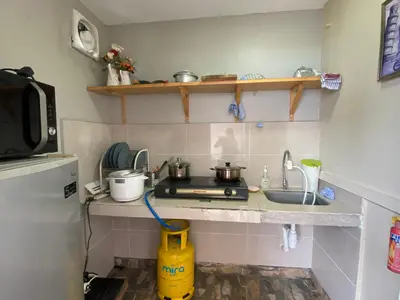 a small kitchen with a stove and a sink at Miharja Studio Private room with Auto gate Parking in Kuala Lumpur