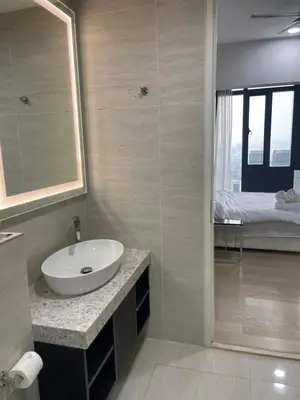 a bathroom with a sink and a mirror and a bed at Star Residences One in Kuala Lumpur