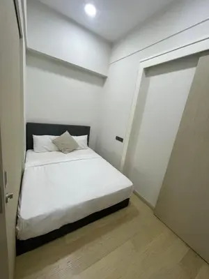 a white bedroom with a bed and a door at Star Residences One in Kuala Lumpur