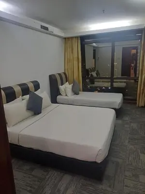 a hotel room with two beds and a couch at Kuala Lumpur Grand service suite at Times Square in Kuala Lumpur