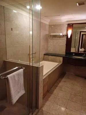 a bathroom with a shower and a tub and a sink at Kuala Lumpur Grand service suite at Times Square in Kuala Lumpur