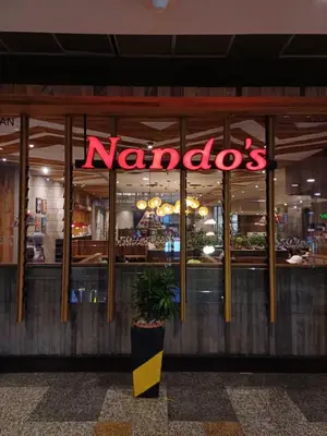a nandos restaurant with a neon sign in the window at Kuala Lumpur Grand service suite at Times Square in Kuala Lumpur