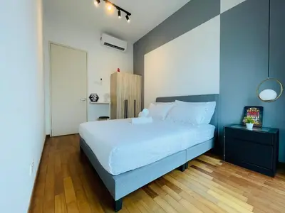 a bedroom with a white bed and a wooden floor at Reizz Residence Ampang by DeUrban in Kuala Lumpur