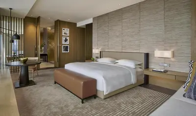 a bedroom with a large bed and a living room at Park Hyatt Kuala Lumpur in Kuala Lumpur
