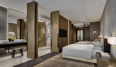 a bedroom with a bed and a bathroom with a sink at Park Hyatt Kuala Lumpur in Kuala Lumpur