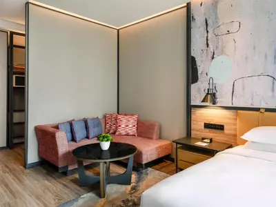 a hotel room with a bed and a couch and a table at Hyatt Centric City Centre Kuala Lumpur in Kuala Lumpur