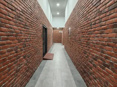 a hallway of a brick wall with a door at Chambers Residence Suites Couple Studio in Kuala Lumpur