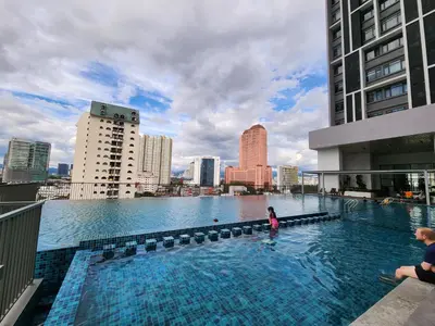 a woman standing in a swimming pool on top of a building at Chambers Residence Suites Couple Studio in Kuala Lumpur