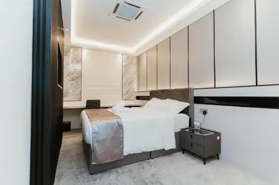 a bedroom with a white bed and a tv at Brilliant Hotel Dan Spa in Kuala Lumpur
