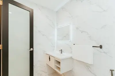 a white bathroom with a sink and a mirror at Brilliant Hotel Dan Spa in Kuala Lumpur
