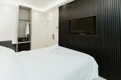 a bedroom with a bed and a tv on a wall at Brilliant Hotel Dan Spa in Kuala Lumpur
