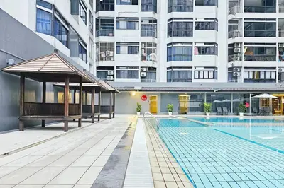 a swimming pool in front of a large building at Fahrenheit Bukit Bintang Big Group 13Pax Family Suites in Kuala Lumpur