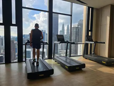 a man walking on a treadmill in a gym looking out the window at AXON Residences Kuala Lumpur in Kuala Lumpur