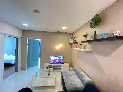 a living room with a couch and a tv at De Home at Summer Suites KLCC in Kuala Lumpur