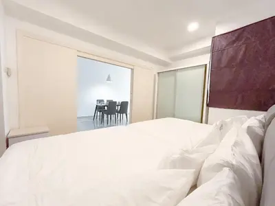 a bedroom with a white bed and a dining room at Solaris Dutamas by Manhattan Group in Kuala Lumpur