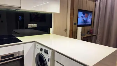 a kitchen with a white counter top with a washing machine at Star Xtian Apartment KLCC in Kuala Lumpur