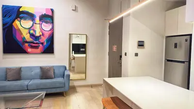 a living room with a blue couch and a painting at Star Xtian Apartment KLCC in Kuala Lumpur